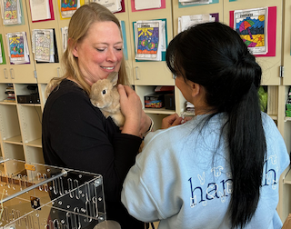 A Hannah team member helping a teacher care for a small classroom pet