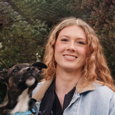 Dr. Kirsten Brown, Doctor of Veterinary Medicine at Hannah Pet Hospital, holding a small brindle dog